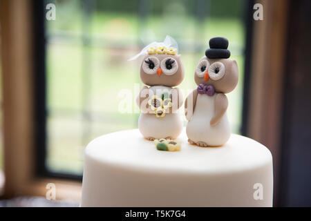 Owl cake topper on a wedding cake, bride and groom owls made from icing sugar on top of a wedding cake Stock Photo