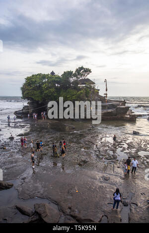 BALI, INDONESIA - JANUARY 26, 2019: Unidentified people by Tanah Lot temple at Bali, Indonesia. It is ancient Hindu pilgrimage temple and one of Bali’ Stock Photo