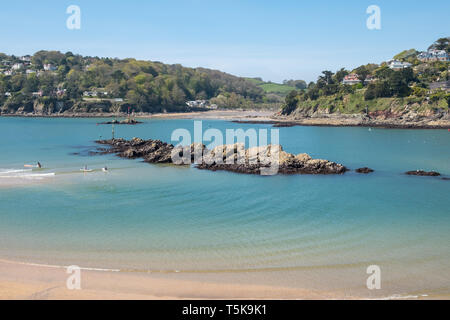 Exposed rocks at low tide at the entrance to the Salcombe estuary with North Sands in the background, South Hams, Devon, UK Stock Photo