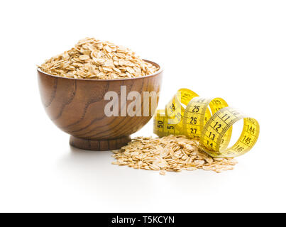 Dry rolled oatmeal and measuring tape isolated on white background. Stock Photo