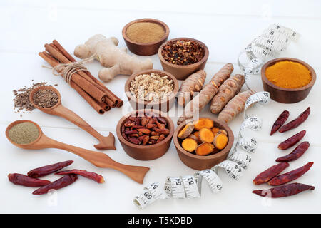 Spices for slimming and weight loss with fresh and dried turmeric, cumin, ginger, chilli, cinnamon and gymnema sylvestre used to suppress appetite. Stock Photo