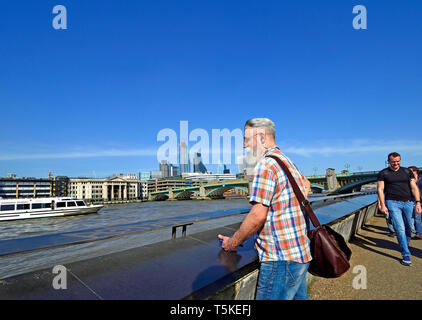 London, England, UK. Bearded man looking out over the River Thames from the South Bank. City of London skyline behind Stock Photo