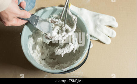 Man builder mixes gypsum putty in a bucket Stock Photo
