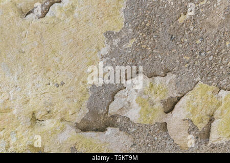 Painted cracked and peeling render coming away from cement background surface. Old paint texture, rough texture. Stock Photo