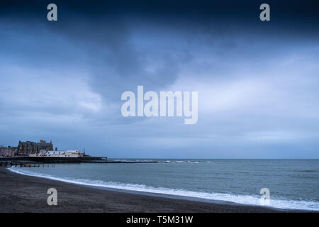 Aberystwyth Wales UK, Thursday 25 April 2019 UK Weather: Dark brooding clouds gather over Cardigan Bay at Aberystwyth, as the latest storm system, Storm Hannah, advances on the UK, bringing winds gusting up to 70mph to western areas this weekeng Photo Credit: keith morris/Alamy Live News Stock Photo