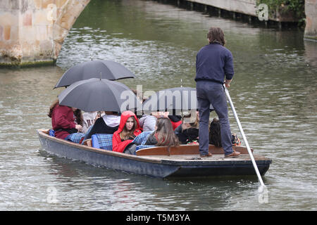 Cambridge, UK. 25th Apr, 2019. After the warm weather over the Bank Holiday Weekend, the temperatures have fallen and rain starts to fall on these people out punting on the river in Cambridge, UK on April 25, 2019. Credit: Paul Marriott/Alamy Live News