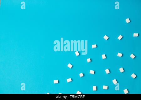 Refined sugar cubes on blue background, top view Stock Photo