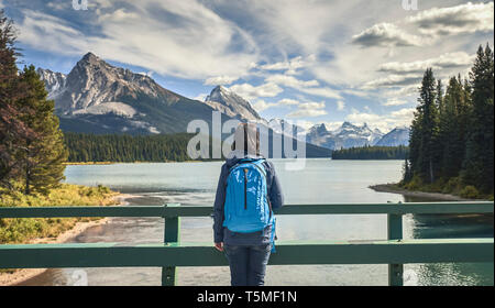 woman looking  by lake at Maligne Lake in Jasper National Park Stock Photo