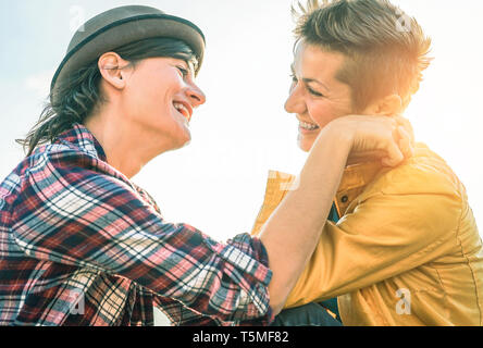 Happy gay couple looking at each other hand to hand - Young women lesbians having a tender moment outdoor Stock Photo