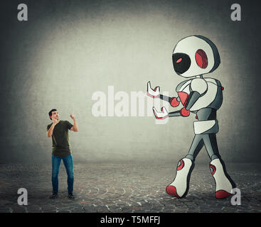 Tiny man ready for battle against giant droid artificial intelligence. Self defense concept, rivalry between people and technology. Risk of losing the Stock Photo