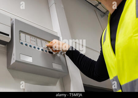 Male Electrician Opening Fire Panel In Server Room Stock Photo