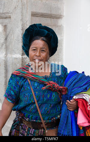 Guatemala lifestyle; Guatemalan woman selling scarves and textiles on the street, Antigua Guatemala Central America - example of Latin America culture