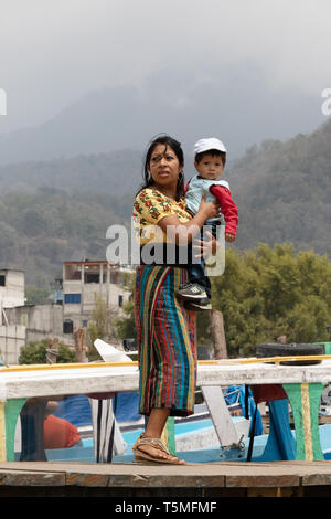 Guatemala people - a young mother and child on the jetty, Santiago Atitlan town; Guatemala Central America
