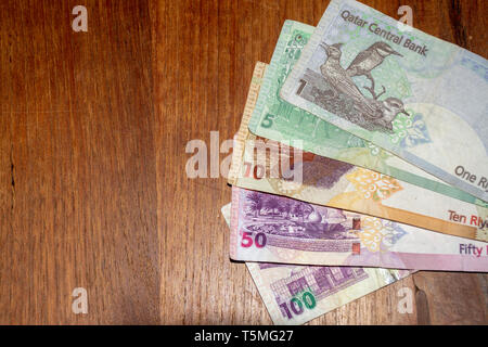 The Currency of the Qatar Riyal notes spread out on the table. Money exchange. Stock Photo