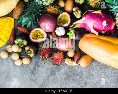 Various fresh Thai fruits - rambutan, mango, mangosteen, longan, papaya, dragon fruit, sapodilla, passion fruit, salak, pineapple on a wooden tray and Stock Photo