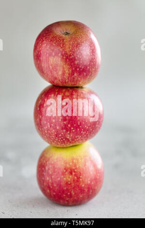Stack of three apples on light background, vertical composition Stock Photo