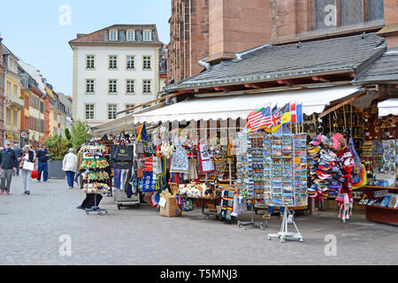 Souvenir shops offering various local trinkets with tourists in front of Church of the Holy Spirit called 'Heiliggeistkirche' at marketplace Stock Photo