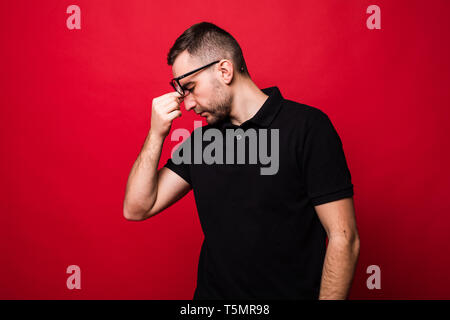 Young man tired isolated on red background Stock Photo