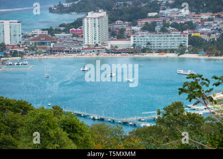 A view of the pier showing boats and hotel and shopping centre Stock Photo