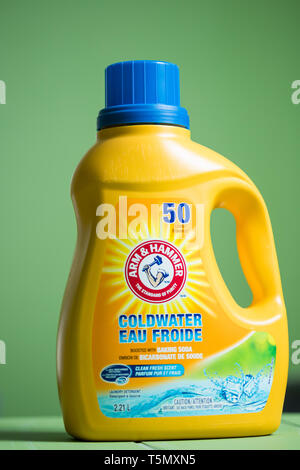 A bottle of Arm and Hammer laundry detergent against a  green background. Arm & Hammer is a registered trademark of Church & Dwight Stock Photo
