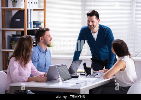Group Of Businesspeople Working On Laptop During Meeting In Office Stock Photo