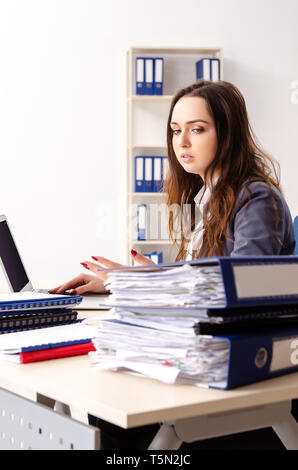 Young female employee unhappy with excessive work Stock Photo