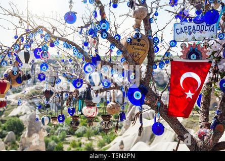 Evil eyes, balloon and Turkish flag on the tree in Goreme panorama Cappadocia, Turkey Stock Photo