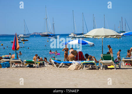 Group of people on the beach. Cala Salada beach. Santa Agnés de Corona. Ibiza. Balearic Islands. Spain. Stock Photo