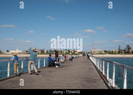 Semaphore Beach, Adelaide, South Australia.   Locals fishing on the jetty of Semaphore, a popular activity among the local community and tourists. Stock Photo