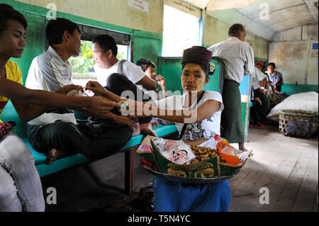 02.09.2013, Yangon, Republic of the Union of Myanmar, Asia - A woman is selling peanuts inside a train compartment on the Circle Line. Stock Photo