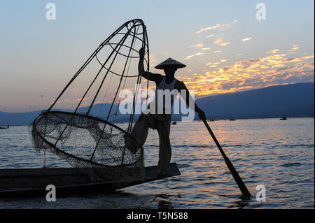 04.03.2014, Nyaungshwe, Shan State, Myanmar, Asia - A one-legged rower is seen fishing along the northern shore of the Inle Lake at dusk. Stock Photo