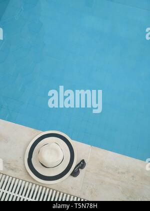 Straw hat with sunglasses near the pool Stock Photo