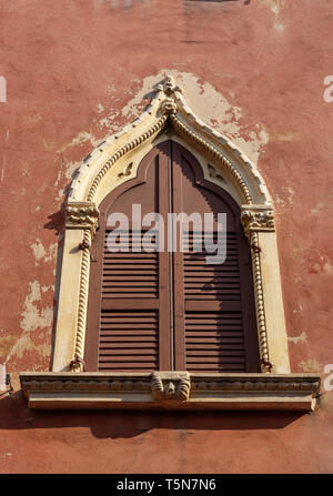 Old arched window with wooden shutters of medieval house in Verona. Italy Stock Photo