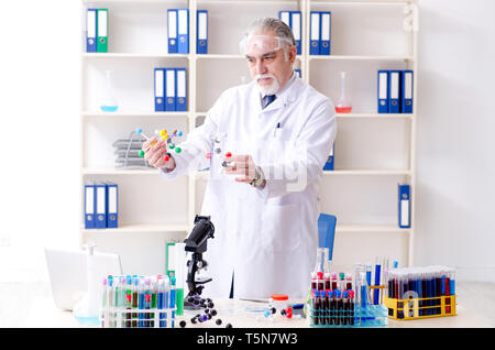 Old male chemist working in the lab Stock Photo