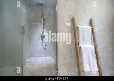 Interior of bathroom with modern shower head and white towel at rail in bathroom. Stock Photo