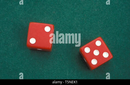 PAIR OF RED DICE ON GREEN FELT SURFACE. Stock Photo