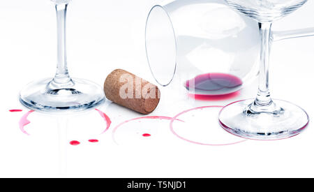 Rest of red wine on a table and empty glasses against white background. End of party concept Stock Photo
