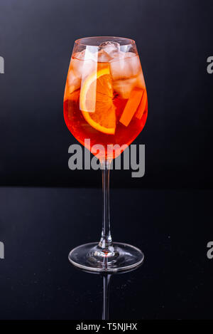 Aperol spritz cocktail in glass on black reflection background. Stock Photo