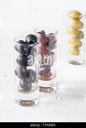 Assortment of three species of olives in glasses on the white background Stock Photo