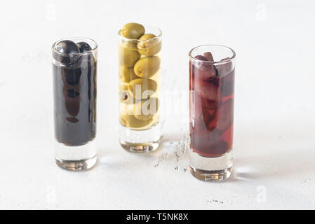 Assortment of three species of olives in glasses on the white background Stock Photo