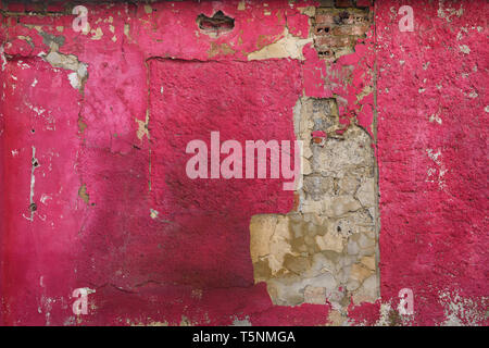 Grunge old background of a brick wall covered with decaying painted plaster Stock Photo