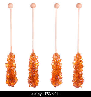 Set of different natural big shiny brown sugar crystals on wooden sticks isolated on white background Stock Photo