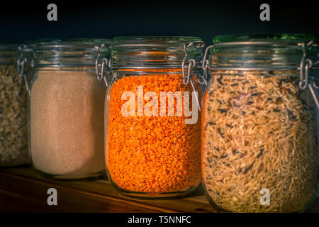 Jars of Dried Legumes and Wholegrain Rice in a Kitchen Pantry Stock Photo