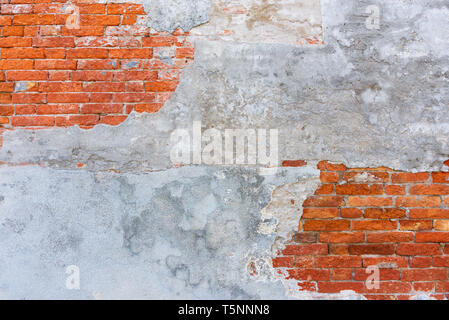 Old brick wall texture, covered with multiply stucco plaster layers, weathered and distressed Stock Photo