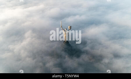 Thick clouds of autumn fog and the Motherland monument sticking out of them Stock Photo