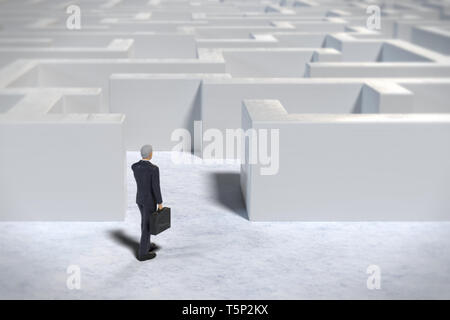 toy miniature businessman figurine entering a white maze structure Stock Photo