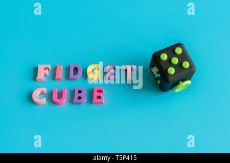 Colorful fingers antistress fidget cube toy in hand on white background.  development of fine motor skills of fingers of children Stock Photo - Alamy