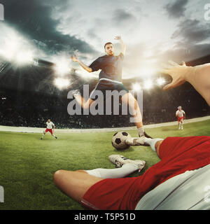Two caucasian fit active men as soccer players fighting with ball at stadium. Game concept. Competitive spirit. 3D model of the stadium was created by Stock Photo