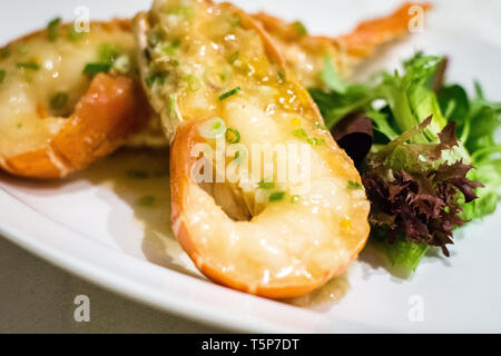 Stir fry Australian lobster with savoury sauce and spring onions and lettuce on the side Stock Photo