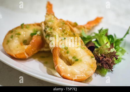 Stir fry Australian lobster with savoury sauce and spring onions and lettuce on the side Stock Photo